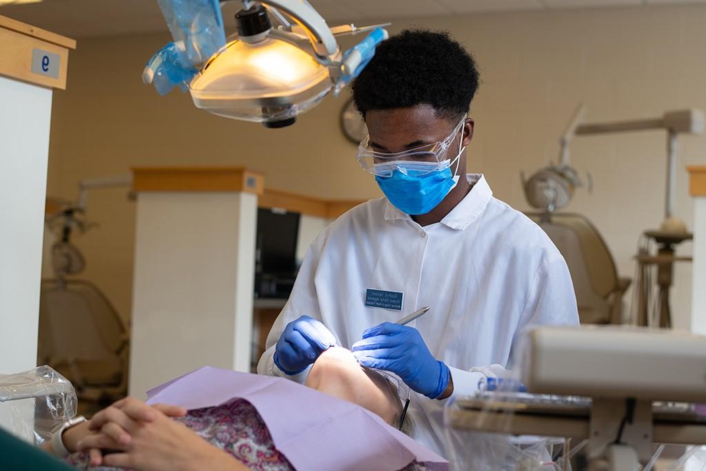 一名学生在口腔卫生诊所为一位病人治疗