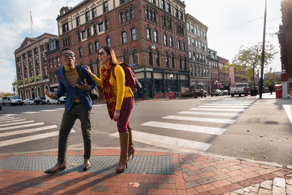 Two University of New Engl和 学生 walk through Portl和, Maine's downtown Old Port area