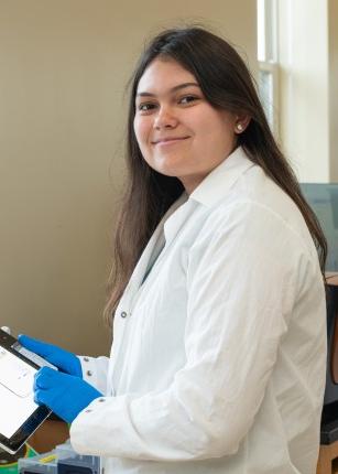 一名学生手持iPad，在波特兰生物技术与健康科学实验室摆姿势